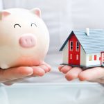 Hands Holding A  Piggy Bank And A House Model